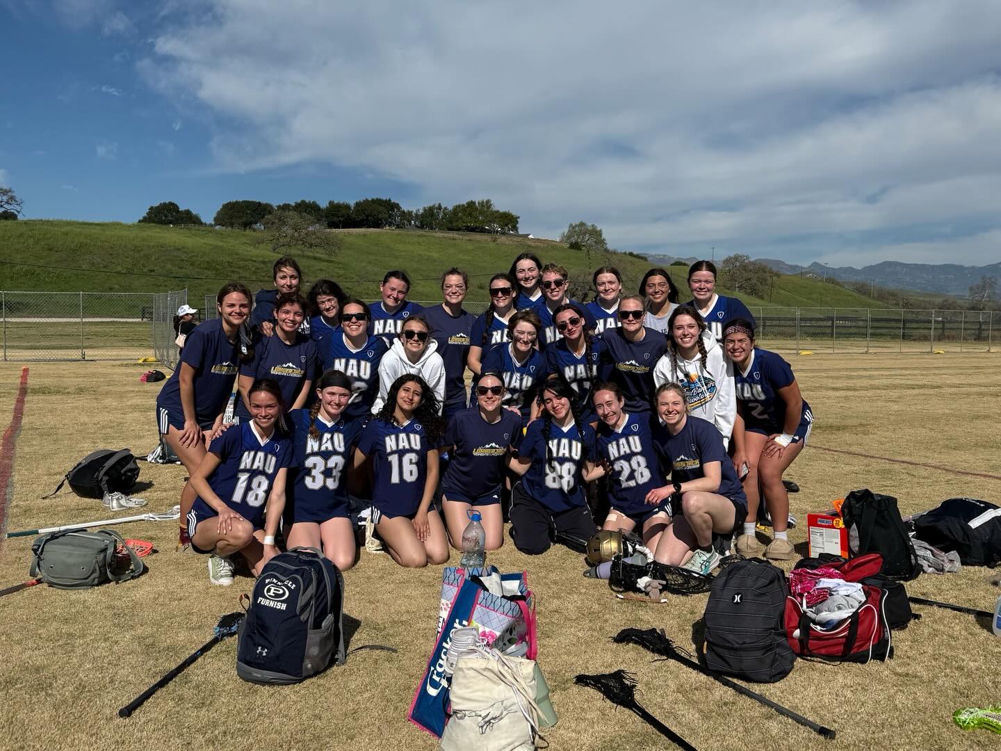 Northern Arizona University Women’s Lacrosse Club team gathered together on the field in Flagstaff